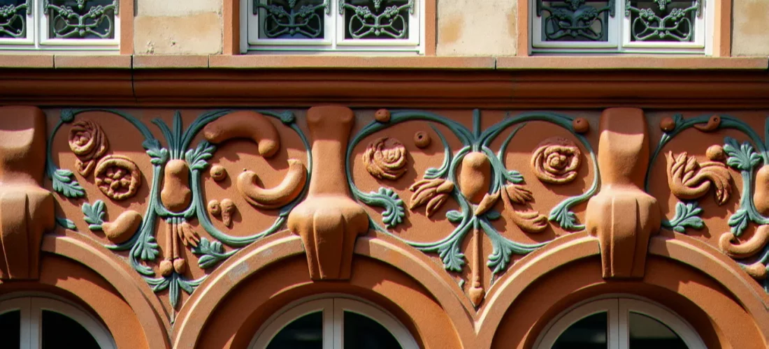 Détail d'une façade en grès flammé Art Nouveau, style céramique architecturale d'Alexandre Bigot, motifs floraux en relief sur un immeuble de la Belle Époque